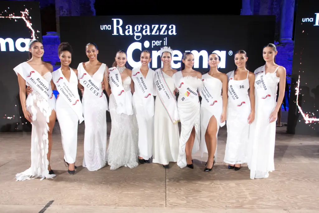 Le finaliste in abito bianco e fascia sul palco della Finale